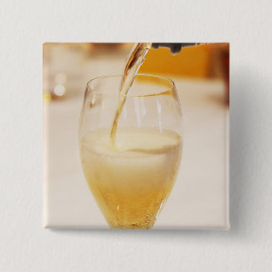 Een champagneglas wordt gevuld met Gosset Vierkante Button 5,1 Cm