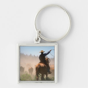 Een cowboy die buiten werkt met de kudde op een ve sleutelhanger