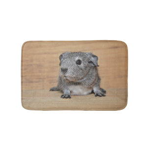 Een Cute Gray Guinee-schop op bruin hout Badmat
