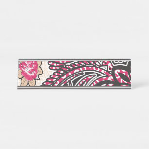 Een decoratief paisley-ontwerp met levendige rode bureau naambordje