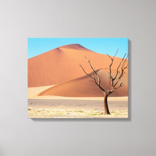 Een dode boom op een woestijnvlakte met duinen canvas afdruk (Voorkant)