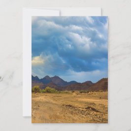 Een droog landschap onder een dramatische, bewolkt feestdagenkaart