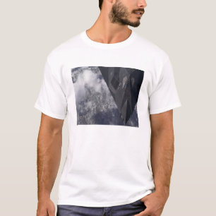 Een F-117A Nighthawk vliegt hoog boven de bergen T-shirt