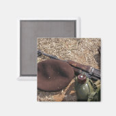 Een geweer, een militaire afdekking en een kantine magneet (Voorkant / Achterkant)