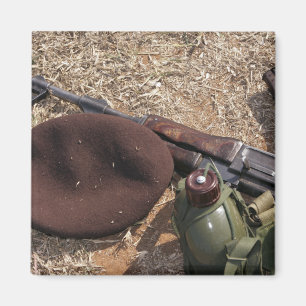 Een geweer, een militaire afdekking en een kantine magneet