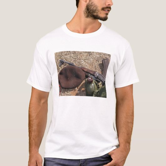 Een geweer, een militaire afdekking en een kantine t-shirt (Voorkant)