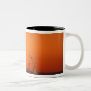 Een giraffenpaar loopt richting de zonsondergang,  tweekleurige koffiemok