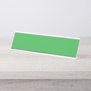 Een groene achtergrond met een witte rand bureau naambordje