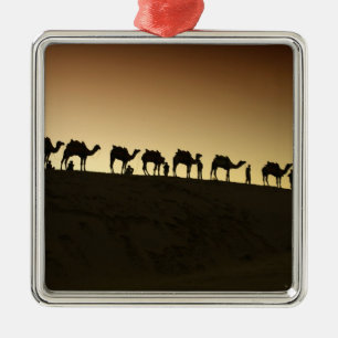 Een groep kameelherders met hun kamelen metalen ornament