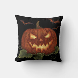 Een grote pompoen met gloeiende ogen en vleermuize kussen