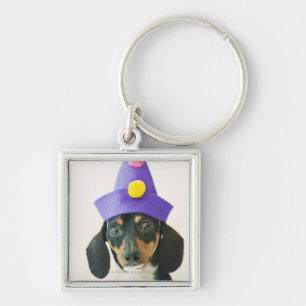 Een hond die een grappig pet draagt sleutelhanger