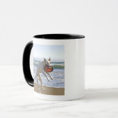 Een hond springt naar een frisbee op het strand mok (Voorkant links)