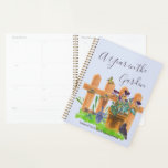 Een jaar in de tuin planner<br><div class="desc">Aangepaste tuinbouwplanner met een begindatum. De cover is lichtblauw met elegant handgeschreven scripttypografie die "A Year in the Garden" leest met een prachtige waterverf van een landhuistuin. Het is voorzien van een hek en een plant pot van pansierbloemen, een grasgras, een zwarte vogel, vlinder en tuinbouwgereedschap. De sjabloon van de...</div>