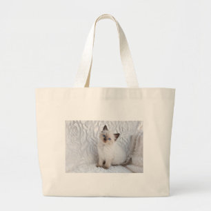 Een jonge ragdolkat zit op de stoel grote tote bag