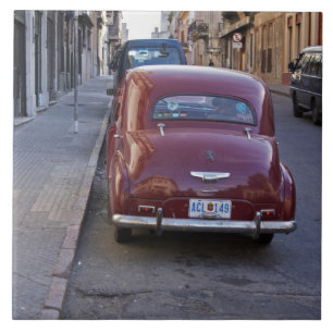 Een klassieke rode Peugeot-auto geparkeerd op stra Tegeltje