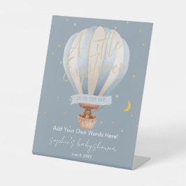 Een kleine ontdekkingsreiziger hete luchtballon op reclamebord met voetstuk