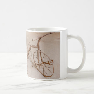 een koffiemok met een foto van een oude driewieler
