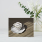 Een kop cappuccino-koffie ligt op een eikel briefkaart (Staand voorkant)