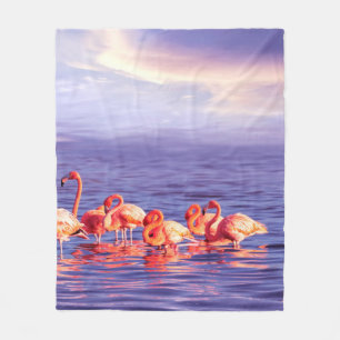 Een kudde mooie roze flamingos tegen een purp fleece deken