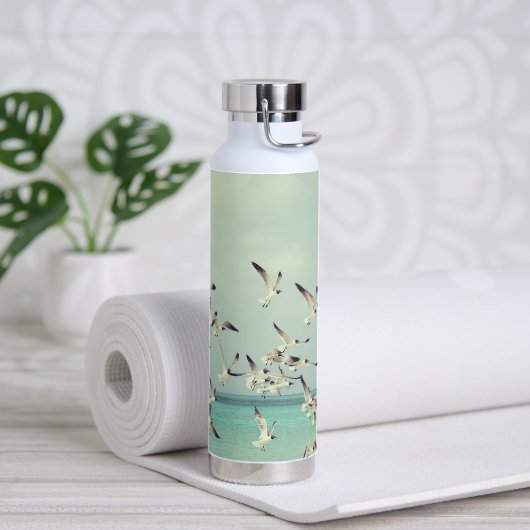 Een kudde vliegende meeuwen boven de oceaan. waterfles (Yoga)