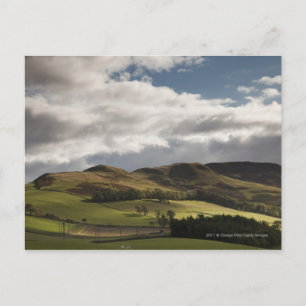 Een landschap met rolheuvels en wolken boven het h briefkaart
