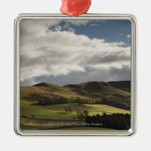 Een landschap met rolheuvels en wolken boven het h metalen ornament