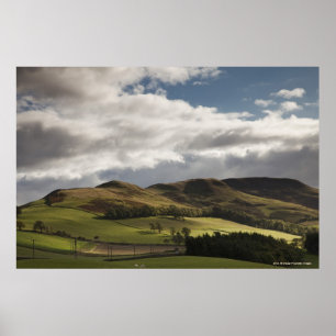 Een landschap met rolheuvels en wolken boven het h poster
