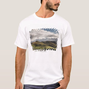 Een landschap met rolheuvels en wolken boven het h t-shirt