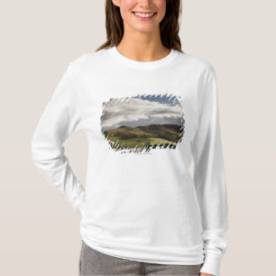 Een landschap met rolheuvels en wolken boven het h t-shirt