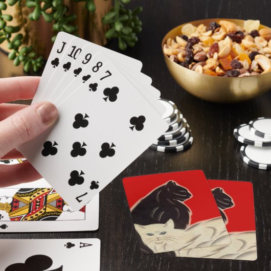 Een leuke kattenpoot poetst roodzwart pokerkaarten (Insitu)