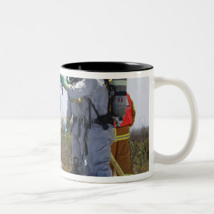 Een luchtman staat in een bad tweekleurige koffiemok