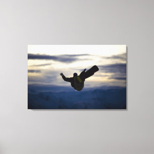 Een mannelijke sneeuwboarder doet een rugflip terw canvas afdruk