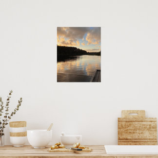 Een meer bij zonsondergang dat de lucht weerspiege poster