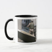 Een militair politieagent gebruikt een breekt rond mok (Links)