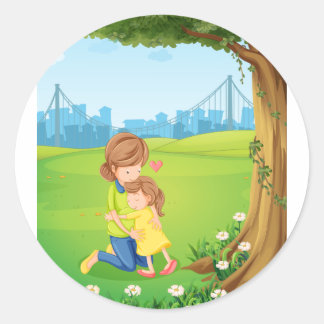 Een moeder knuffelt haar dochter onder de boom ronde sticker