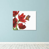 een monarch bezoekt een bouquet rode tulpen canvas afdruk (Insitu (Houten vloer))