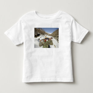 Een Mujahadeen Guard loopt met een Amerikaans mili Kinder Shirts