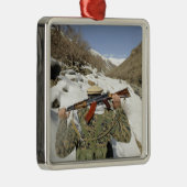 Een Mujahadeen Guard loopt met een Amerikaans mili Metalen Ornament (Rechts)