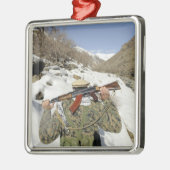 Een Mujahadeen Guard loopt met een Amerikaans mili Metalen Ornament (Links)