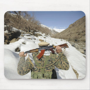 Een Mujahadeen Guard loopt met een Amerikaans mili Muismat