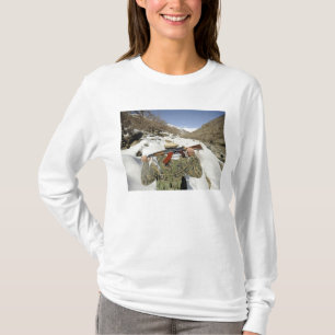 Een Mujahadeen Guard loopt met een Amerikaans mili T-shirt
