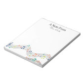 Een notitie van kleurrijke muzieknotitie over het  notitieblok (Linkerzijde)