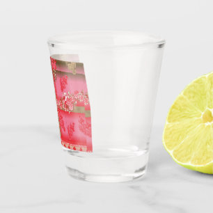 Een ontwerp van een roze en gouden achtergrond met shot glas