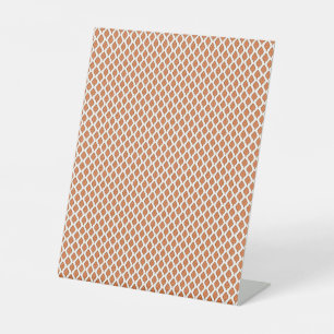 Een oranje en wit geometrisch patroon reclamebord met voetstuk
