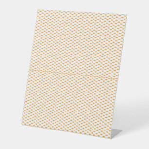 Een oranje en witte achtergrond met kleine cirkels reclamebord met voetstuk