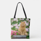 Een Oranje kat in een tuin met roze lentbloemen Tote Bag (Achterkant)