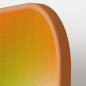Een oranje pickleball-paddle met een gestructureer pickleball paddle (Links Detail)