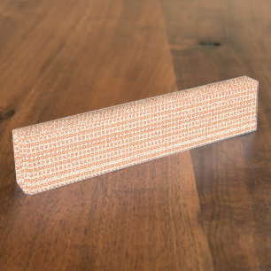 Een oranje vloerkleed met een textuurpatroon ligt naambordje