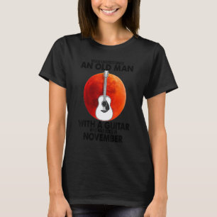 Een oude man met een gitaar die in november is geb t-shirt
