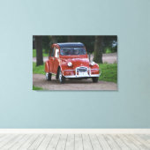 Een oude rode Citroen 2CV auto met een lachende vr Canvas Afdruk (Insitu (Houten vloer))